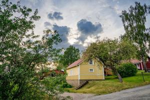 a small yellow house on the side of a street at Mökki maaseudulla in Raikku