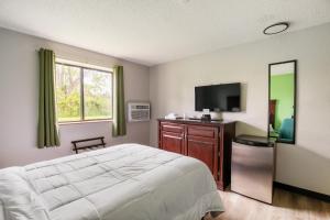 a bedroom with a bed and a flat screen tv at Studio in Lansing in Lansing