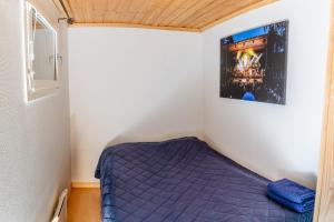a small bedroom with a purple bed in it at Mökki maaseudulla in Raikku
