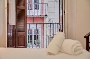 a stack of towels on a bed in front of a window at PAMPLONA CENTER SUITES luxury apartament City center in Pamplona