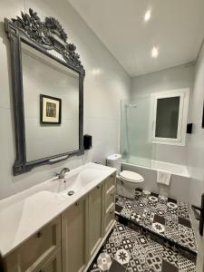 a bathroom with a sink and a toilet and a mirror at PAMPLONA CENTER SUITES luxury apartament City center in Pamplona +33 photos