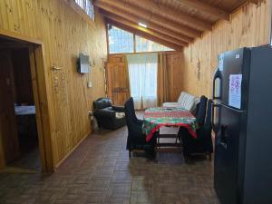 a room with a table and chairs and a refrigerator at Casa Quinta El Tabo in El Tabo