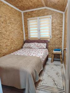 a small bedroom with a bed and a window at Mubina Apartman in Ćukovi
