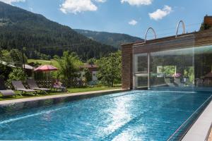 a swimming pool with a mountain in the background at Landhotel Alpenhof Filzmoos in Filzmoos