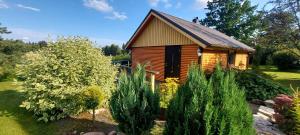 a wooden cabin with a garden in front of it at Tuka Talu ,Soomaa piirkonnas, Pärnumaa in Tori