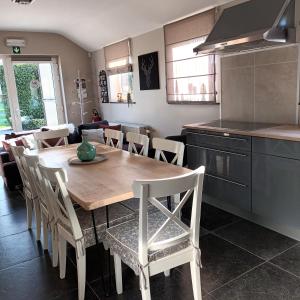 a kitchen and dining room with a wooden table and chairs at Le Relais De La Motte in Soignies