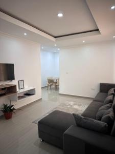 a living room with a couch and a flat screen tv at Blue leaf apartments in Lusaka