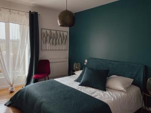 a bedroom with a bed and a red chair at Maison de Pauline, Chablis Vineyard in Préhy