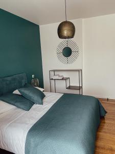 a bedroom with a bed with a green accent wall at Maison de Pauline, Chablis Vineyard in Préhy +10 photos