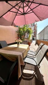 a table and chairs under a pink umbrella on a balcony at Bellaria Casa Indipendente-Giardino Privato-Parcheggio Privato-Strategic Location 5 Terre-Portofino in Rapallo