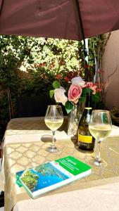 a table with two glasses and a book and a bottle of wine at Bellaria Casa Indipendente-Giardino Privato-Parcheggio Privato-Strategic Location 5 Terre-Portofino in Rapallo +25 photos