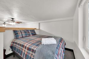 a small bedroom with a bed with a plaid blanket at Alpenglow in Brighton