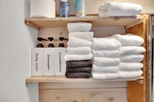 a bunch of towels on a shelf in a bathroom at Alpenglow in Brighton +10 photos