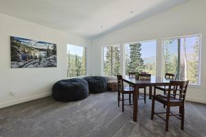 a dining room with a table and chairs and windows at Silverview Lodge in Brighton
