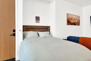 a bed in a white room with a large bed at Milly Slopeside Studio in Brighton