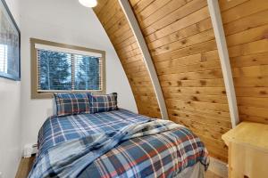 a bedroom with a bed and a wooden wall at Chalet at Brighton in Brighton