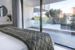 a bedroom with a bed and a large window at The L Smart Suite - Premium & Minimal in Ierapetra