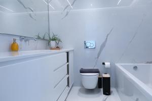 a bathroom with a toilet and a tub and a sink at The L Smart Suite - Premium & Minimal in Ierapetra