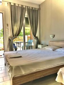 a bedroom with a large bed and a balcony at Soso studios & apartments in Stavros