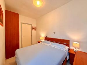 a bedroom with a white bed and two lamps at Villa Chiara in Follonica