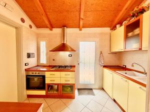 a kitchen with a stove top oven next to a sink at Villa Chiara in Follonica +24 photos