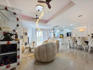 a large living room with a ceiling fan and chairs at Evolve Madhura in Peliyagoda