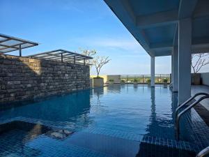 a swimming pool with a brick wall and blue water at Evolve Madhura in Peliyagoda