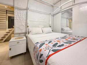 a white bedroom with a bed and a staircase at Evolve Madhura in Peliyagoda +24 photos