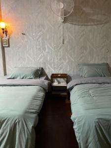two twin beds in a room with a fan at PAMA'Pranakorn in Bangkok +34 photos