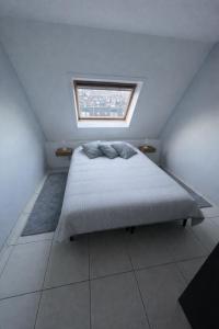 a bedroom with a large bed with a window at Residentie Sofie in Koksijde