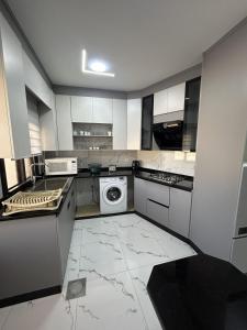 a kitchen with white cabinets and a washer and dryer at golden apartment - karak - thaniyah الكرك الثنية in Kerak