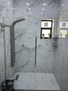 a white bathroom with a shower with a window at golden apartment - karak - thaniyah الكرك الثنية in Kerak +36 photos