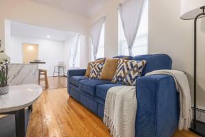 a living room with a blue couch and a table at Cozy Room in the City of Worcester in Worcester