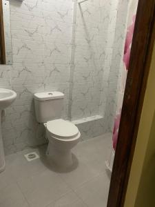 a white bathroom with a toilet and a sink at Casa Almasi in Nairobi +25 photos
