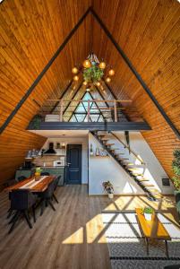 a living room with a wooden ceiling and a staircase at Cabana A-frame D&J in Mada