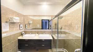 a bathroom with two sinks and a shower at Villa De Shalom in Ocho Rios