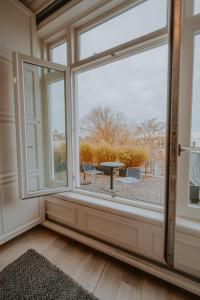 a room with a large window with a table and chairs at Boutique Hotels MANNA & Blue in Nijmegen