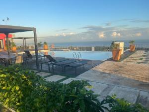 a swimming pool with a table and chairs and the ocean at Villa De Shalom in Ocho Rios