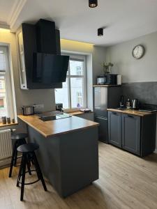a kitchen with a counter and a sink and a stove at Apartament u Laury in Mrągowo