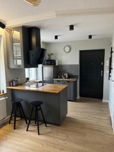 a kitchen with a counter with stools and a counter top at Apartament u Laury in Mrągowo