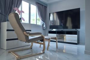 a living room with a chair and a television at GORGEOUS NEW DESIGNED 4br KataBeach sweetHome in Kata Beach