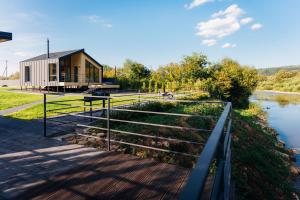a house on the side of a river with a fence at Rika chalet in Stantsiya Dembina
