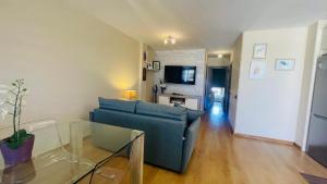 a living room with a blue couch and a table at Casa Sony El Cotillo in El Cotillo