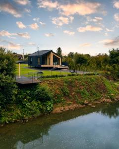 a house on a hill next to a river at Rika chalet in Stantsiya Dembina