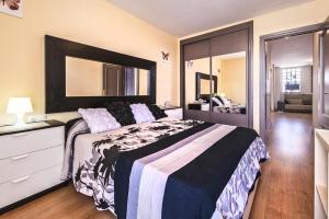 a bedroom with a large bed with a dresser and a mirror at Casa Sony El Cotillo in El Cotillo