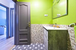a green bathroom with a sink and a door at Casa Sony El Cotillo in El Cotillo +19 photos