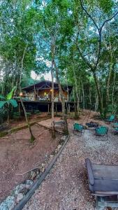 a house in the woods with benches and trees at Casa do Cipó - Espaço Rio da Lua - São Jorge GO in Sao Jorge
