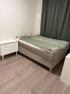 a bed in a room with a dresser and a bed sidx sidx at Apartment 3 minutes from cablecar in Tromsø