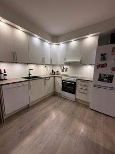 a kitchen with white cabinets and white appliances at Apartment 3 minutes from cablecar in Tromsø +19 photos