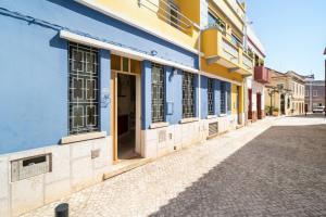 a blue and yellow building on a street at Mesquita in Silves